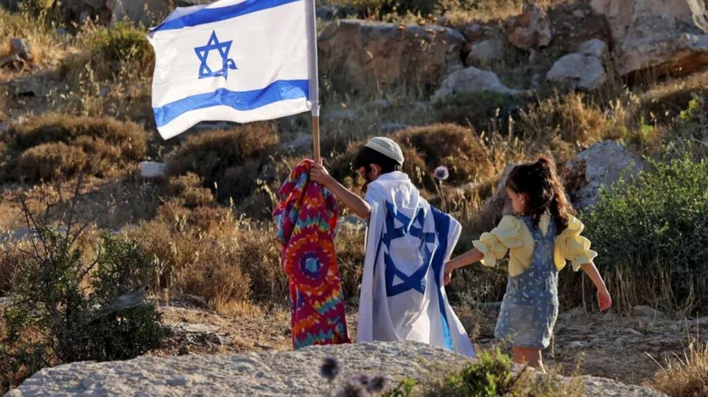Israeli children walk in the West Bank on the outskirts of Hebron