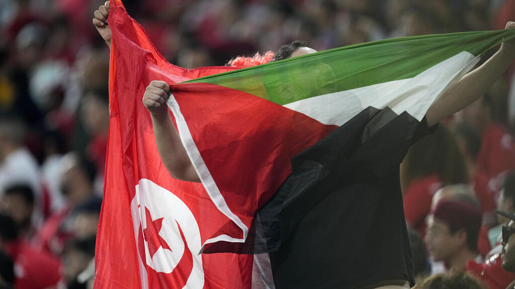אוהד נבחרת טוניסיה עם דגל פלסטניאי