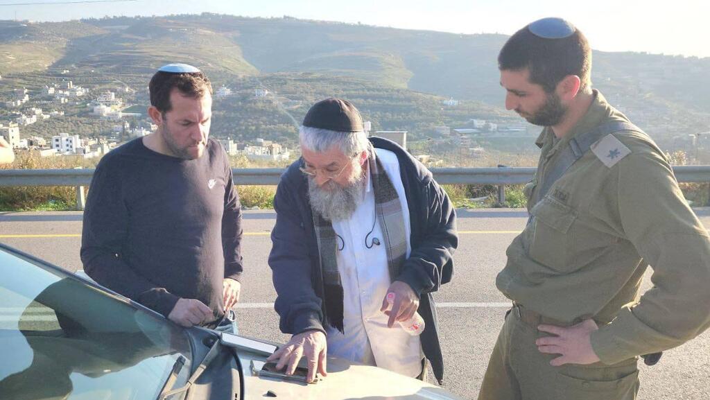 ניצול הפיגוע, שמואל ריניץ, יחד עם ראש המועצה יוסי דגן (צילום: רועי חדי) הרכב שנפגע