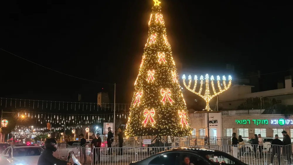 A Christmas tree next to a Hanukkah candlestick in Haifa, Israel, during the Hag HaHagim festival 