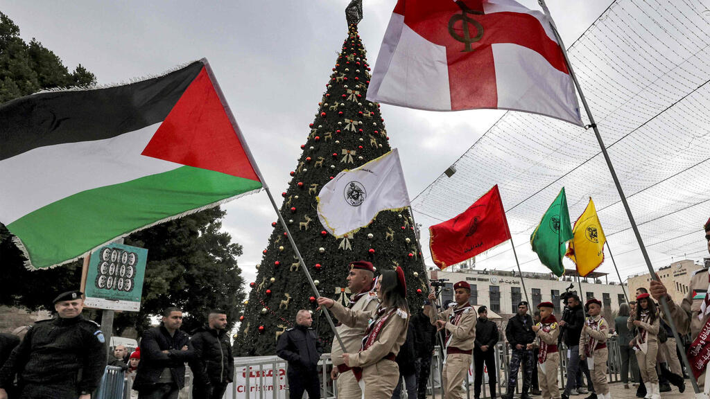 Members of the scouting movement march during Christmas eve celebrations at the Manger Square outside the Church of the Nativity (Photo: AFP) חגיגות חג המולד בבית לחם