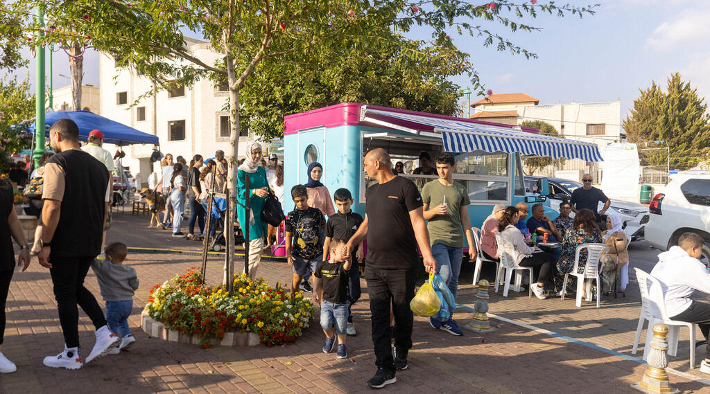 People enjoy a food truck in a plaza in Ghajar, Oct. 14, 2022