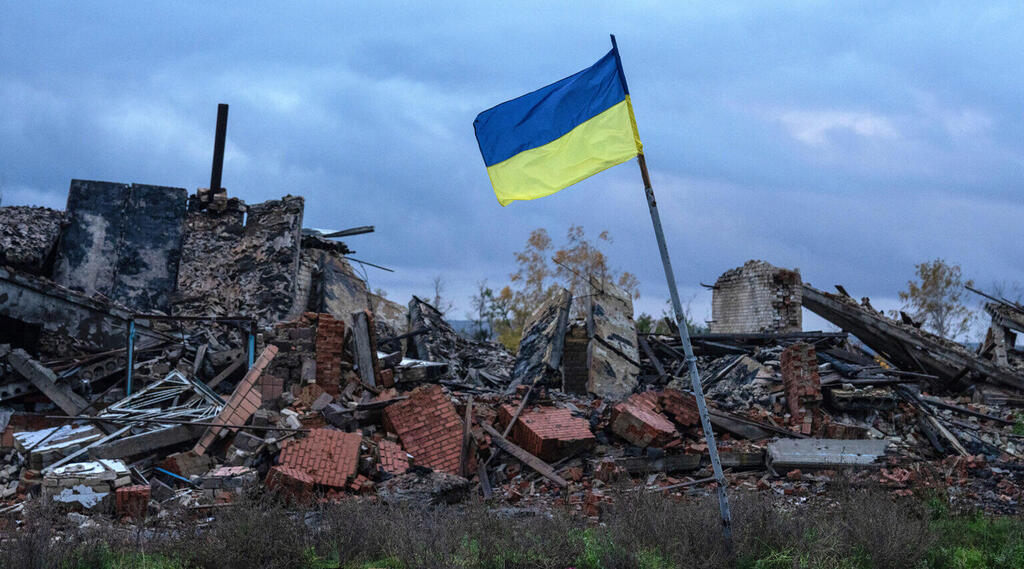 A Ukrainian flag flies above the ruins of buildings destroyed during fighting between Ukrainian and Russian forces Kam'yanka, in the Kharkiv oblast of Ukraine, Oct. 24, 2022 