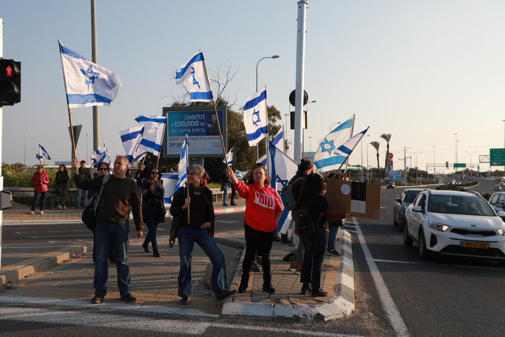 מפגינים לצד כביש 40 ליד גדרה (צילום: דנה קופל ) מחאות נגד מהפכה משפטית בגדרה