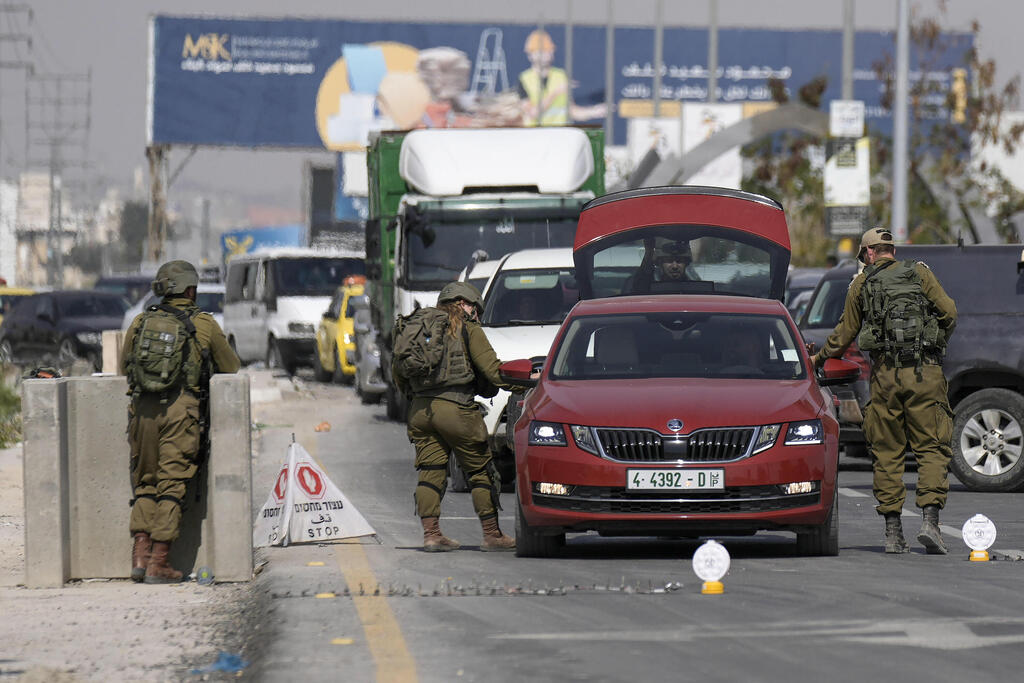 מחסום צה"לי ליד יריחו, היום, כחלק מהמצוד אחר חוליית המחבלים (צילום: AP ) מחסום של צה"ל לוחמים מחפשים ברכבי פלסטינים באזור יריחו כחלק מ מצוד אחר מחבלים מ פיגוע בצפון ים המלח שבו נרצח אילן גנלס