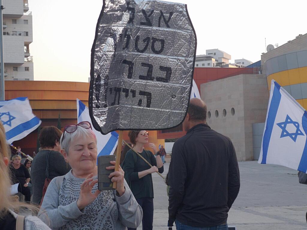 Elderly woman with sign saying she's had enough with dictatorships back in Stalin's time