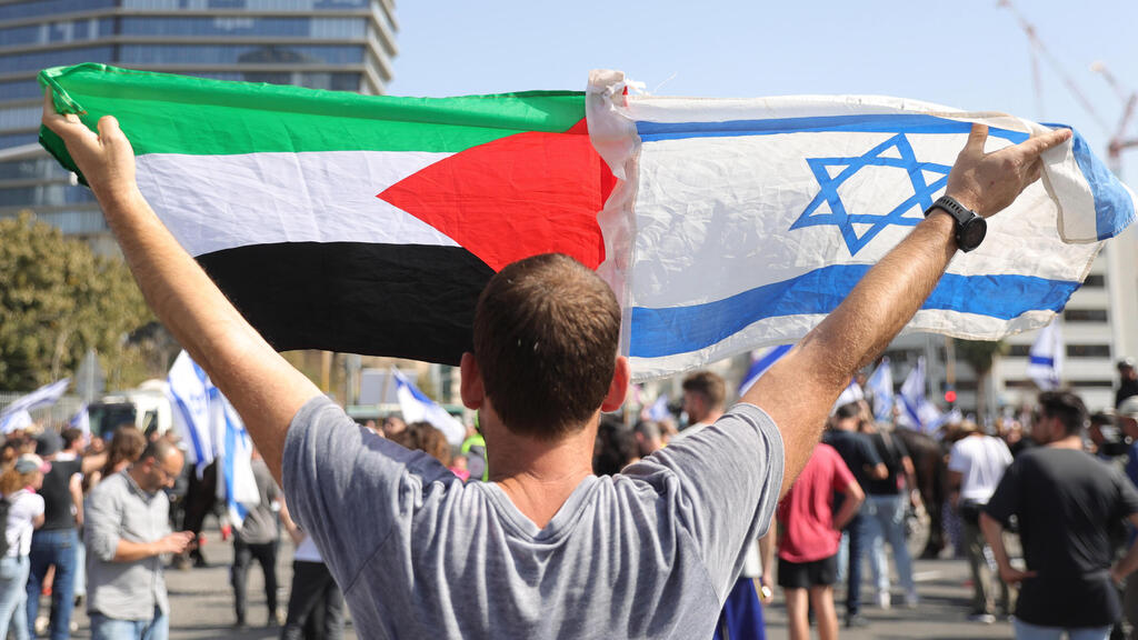 מפגין מניף את דגל הרשות הפלסטינית בתל אביב