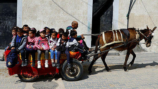 Loay Abu Sahloul takes the children to school on his donkey cart