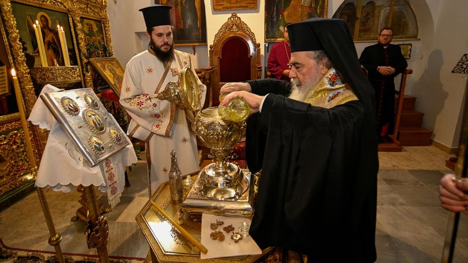 Greek Orthodox Patriarch of Jerusalem Theophilos III mixes the oils from the Mount of Olives to make Chrism Oil, which will be used in the coronation of Britain's King Charles on May 6, in Jerusalem, March 3, 2023 