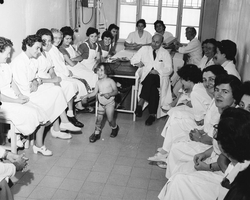 כ-12 אלף איש בישראל נותרו נכים. ילדה שנפגעה מנגיף הפוליו בשנות ה־50, מוקפת בצוות מטפלים (צילום: דוד רובינגר) ילדה שנפגעה מנגיף הפוליו בשנות ה־50, מוקפת בצוות מטפלים