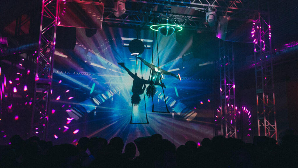 An aerialist performs while hanging above the crowd at Silo in Brooklyn 