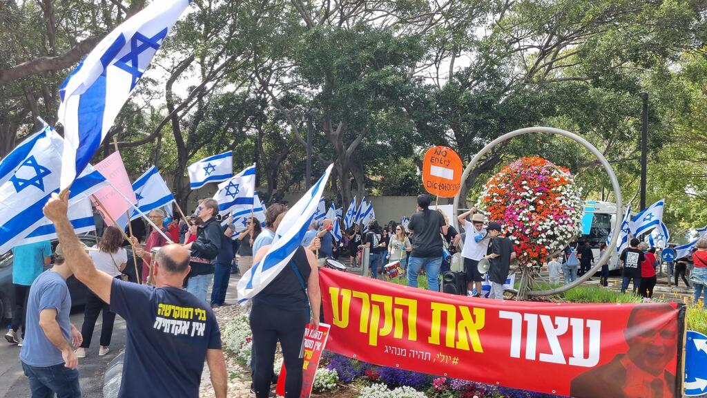 מפגינים ליד בית אדלשטיין בהרצליה. הוא אמר: "חייבים לפתוח דיון על זה" (צילום: עידו ארז) הפגנה מול ביתו של יולי אדלשטיין בהרצליה