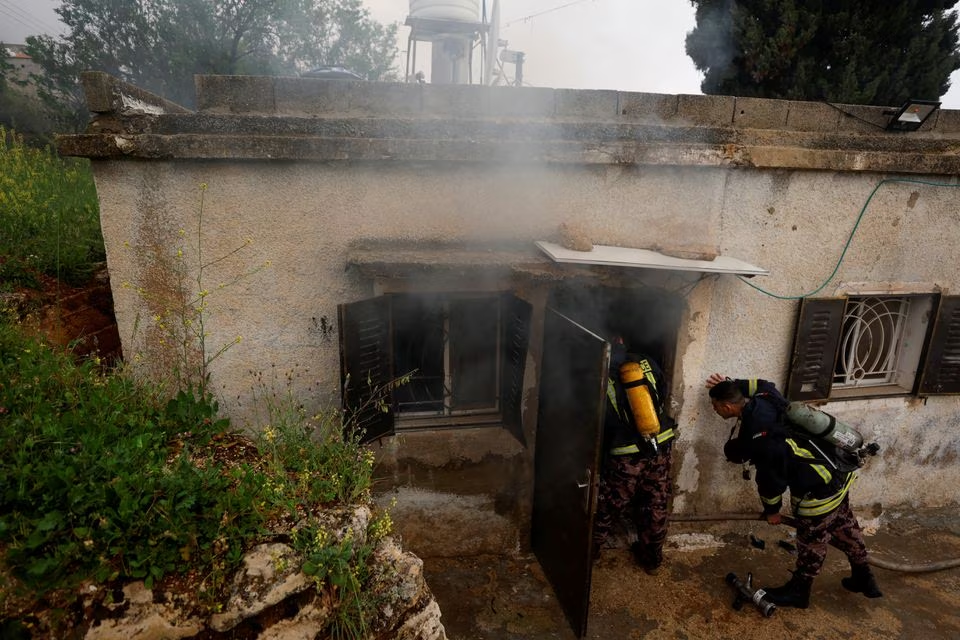  Firefighters work at a Palestinian house which Palestinians say was attacked by Israeli settlers near Ramallah in the Israeli-occupied West Bank, March 26, 2023 