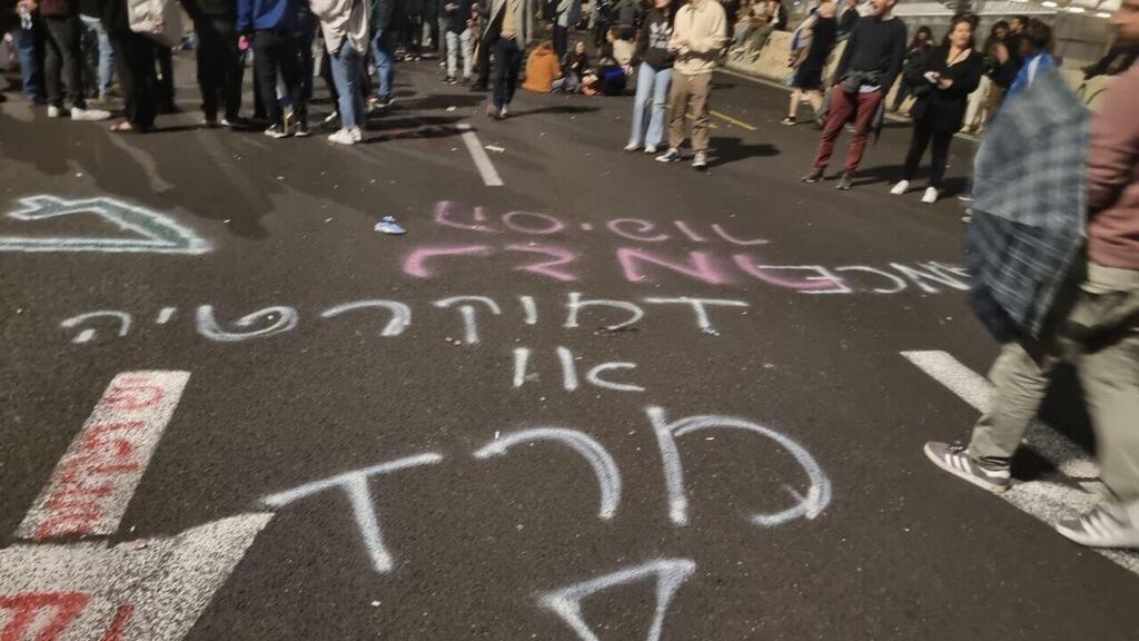 הכתובות על איילון. "דמוקרטיה או מרד" (צילום: לירן לוי) כתובות גרפיטי רוססו על נתיבי איילון במהלך המחאה נגד המהפכה המשפטית