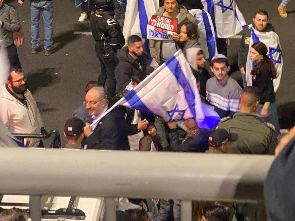 ח"כ ניסים ואטורי עם הדגל בנתיבי איילון (צילום: אדם קוטב) ניסים ואטורי חוסם את נתיבי איילון בהפגנה בעד ההפיכה המשפטית