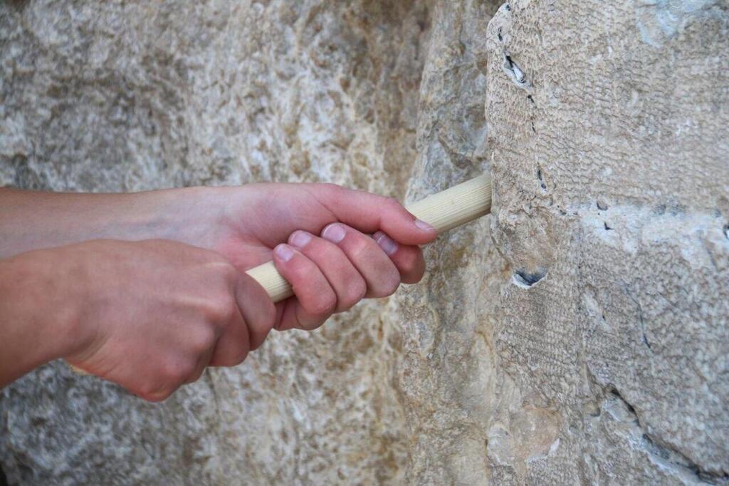 Cleaning the Western Wall before Passover