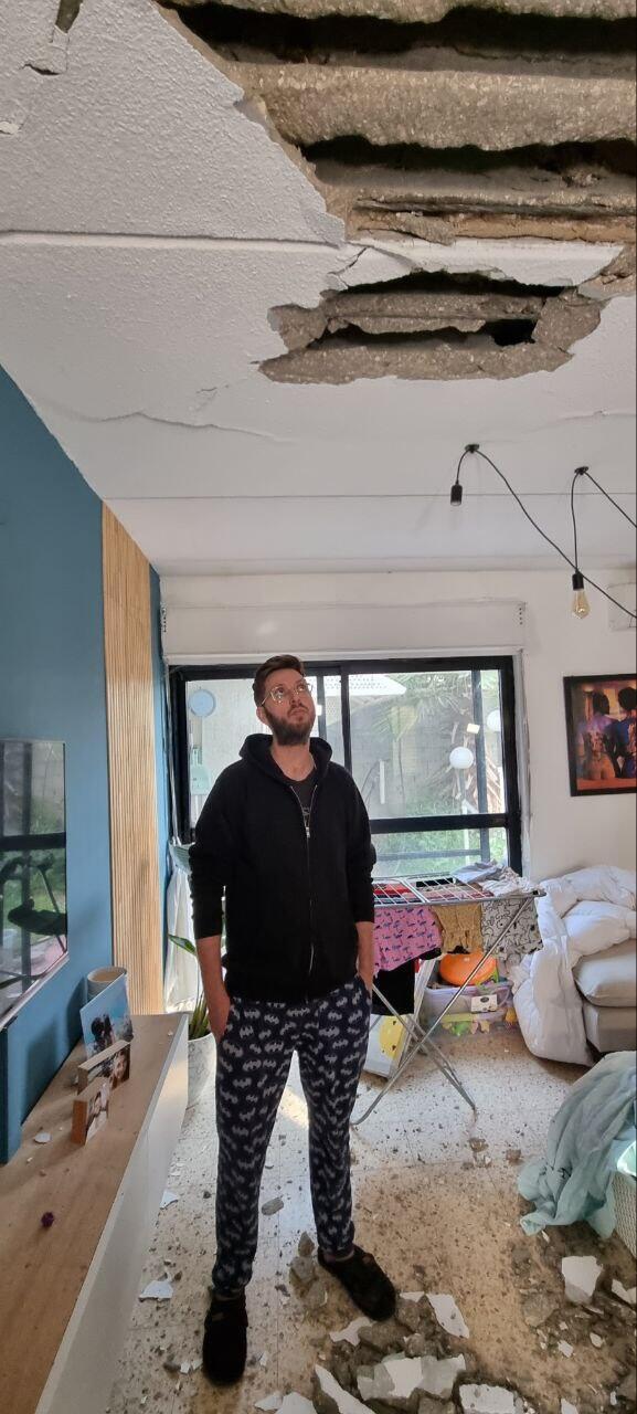 יניר וזאנה שביתו נפגע מרקטה, מביט על הנזק בתקרה ( צילום: רועי עידן) יניר וזאנה שביתו נפגע מרקטה