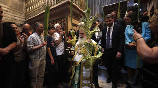 Greek Orthodox Patriarch of Jerusalem Theophilos III (C) holds palm branches as he takes part in the Orthodox procession during Palm Sunday in the Church of the Holy Sepulcher in Jerusalem, April 9, 2023 