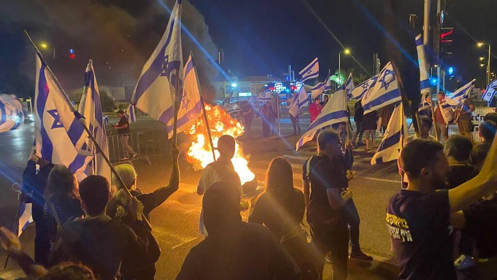 מפגינים מבעירים צמיג בצומת כרכור מדורה במהלך ההפגנה בצומת כרכור