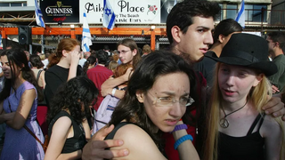 Young Israelis hug as they take part in a memorial gathering at the beachfront Tel Aviv bar, Mike's Place, which was hit by a suicide bomber 