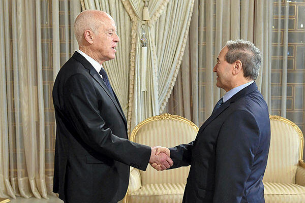 Tunisia's President Kais Saied (L) receiving Syrian Foreign Minister Faisal Mekdad