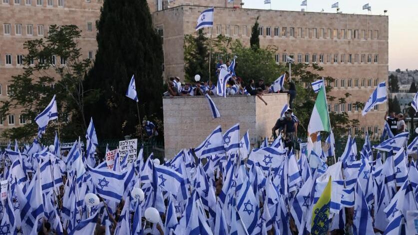 Pro-government protesters wave the Israeli flag 