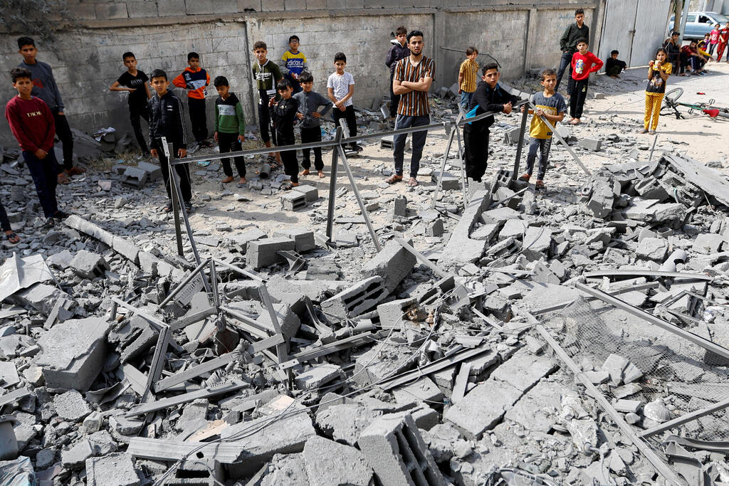 People stand on the rubble of the building struck by IDF killing PIJ commanders 