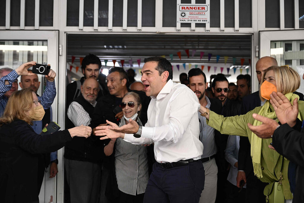 "חיים על תלושי סיוע". ציפרס אחרי שהצביע בקלפי (צילום: AFP) יוון בחירות מנהיג מפלגת השמאל אלכסיס ציפרס פוגש בוחרים ב קלפי