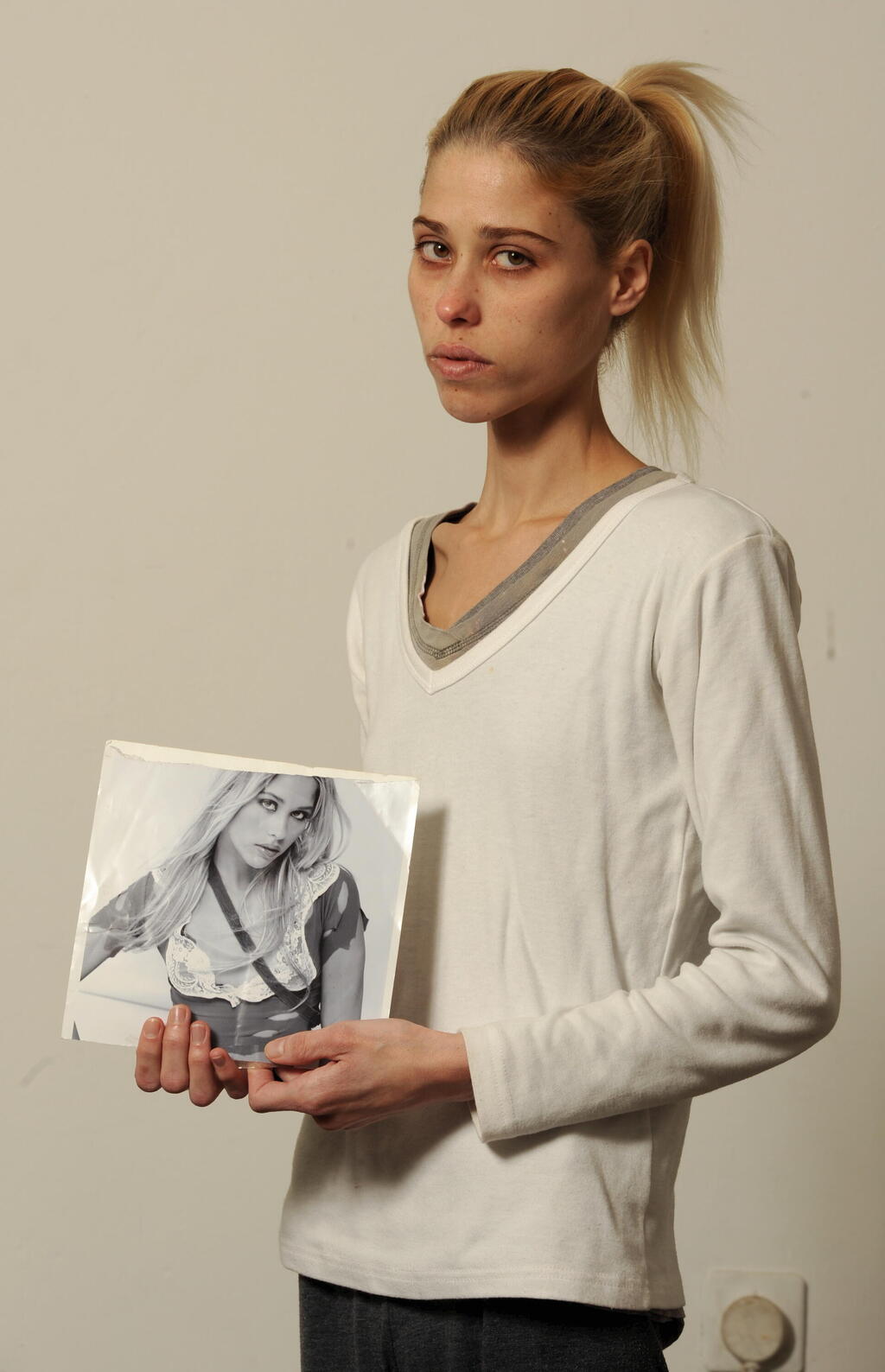 קארין באומן עם תמונה שלה מתקופת הדוגמנות