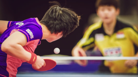 A table tennis tournament. The player's skill at applying spin to the ball can drastically alter its trajectory and present a challenge for the opponent, who must correctly anticipate and compensate for the ball's rotation. This curving motion is explained by the Magnus effect 