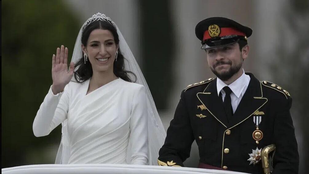 Jordan's Crown Prince Hussein and Saudi Rajwa Alseif wave to well-wishers during their wedding ceremonies in Amman 
