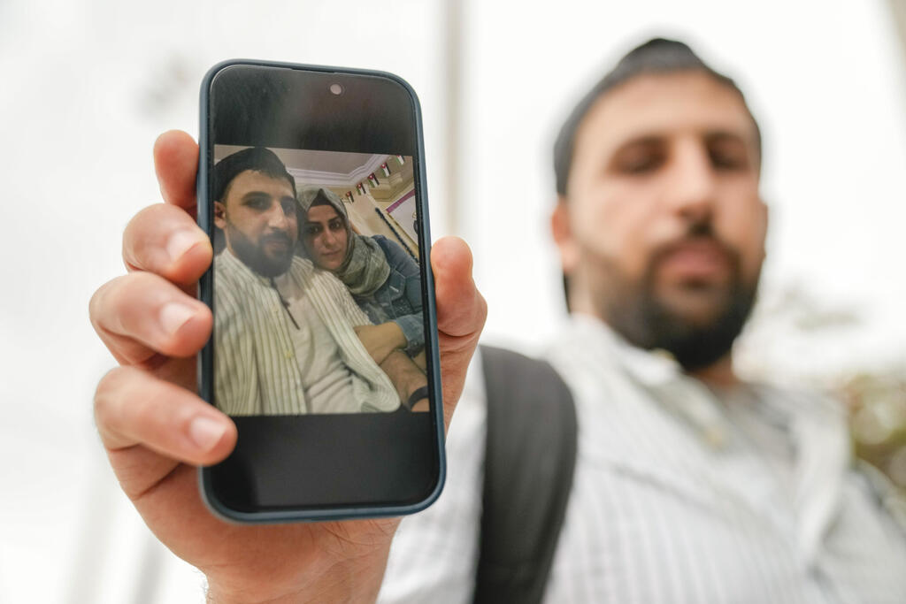 קאסם, מהגר שהשתקע בגרמניה, מציג בקלמטה את תמונתו עם אשתו, שהיא ואחיה היו על הסירה, ועדיין נעדרים (צילום: AP) יוון אסון טביעת ספינה של מהגרים קאסם מהגר ש בא מ גרמניה לחפש את אשתו ואחיה שהיו על הספינה