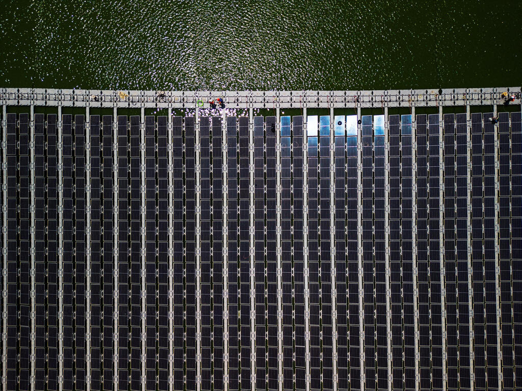 An aerial view shows solar panels on a water reservoir 