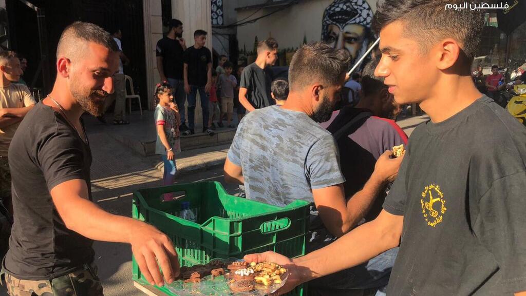 במחנה בורג' אל-בראג'נה מחלקים ממתקים לאחר הפיגוע בעלי