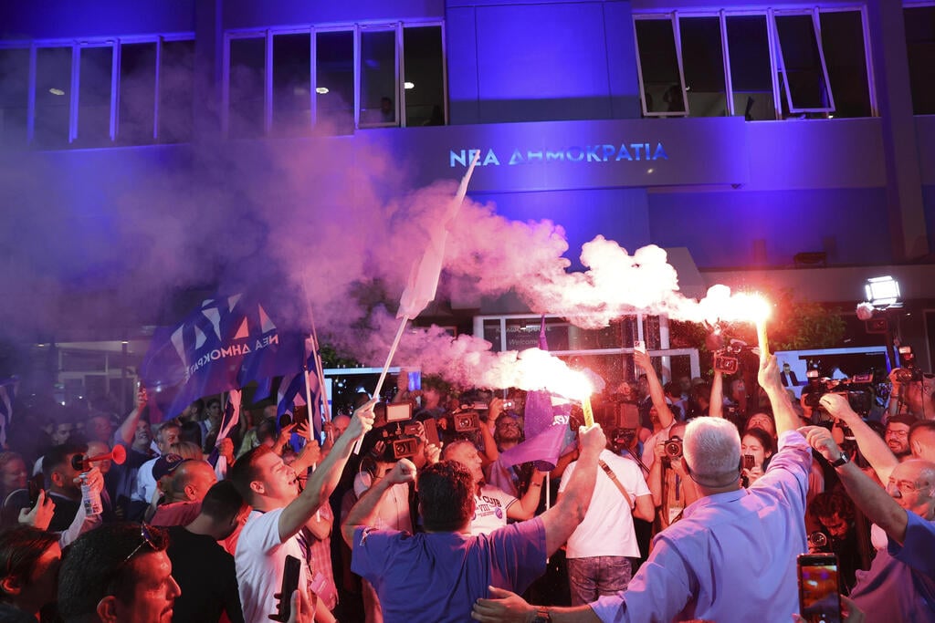 הניצחון הושלם אחרי חמישה שבועות של המתנה. תומכי מיצוטקיס חוגגים (צילום: AP) ראש ממשלת יוון קיריאקוס מיצוטקיס ניצחון בחירות