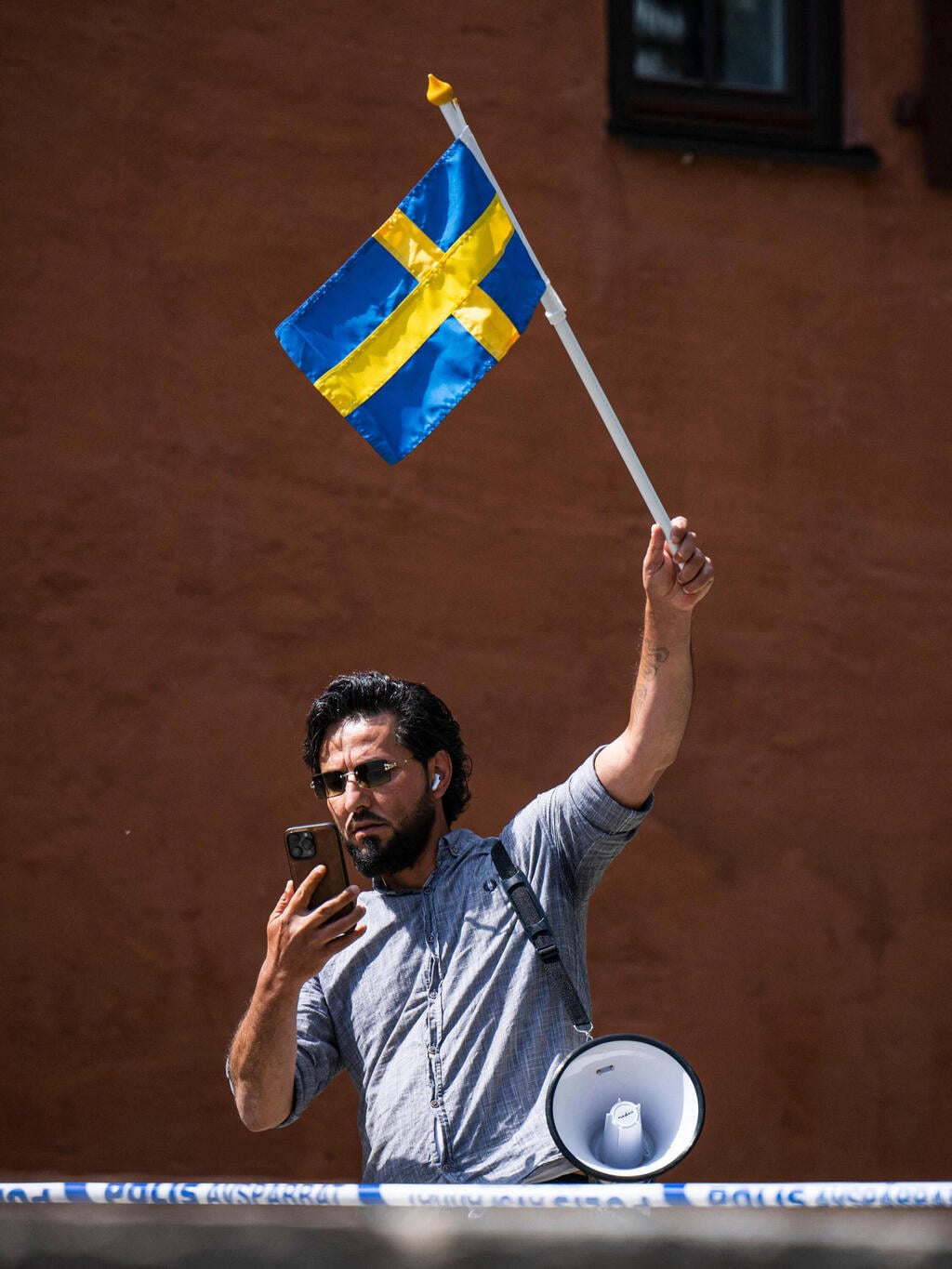 צילום: AFP פעיל במהלך הפגנה שבה הצית שרף קוראן מולך מסגד ב שטוקהולם שבדיה