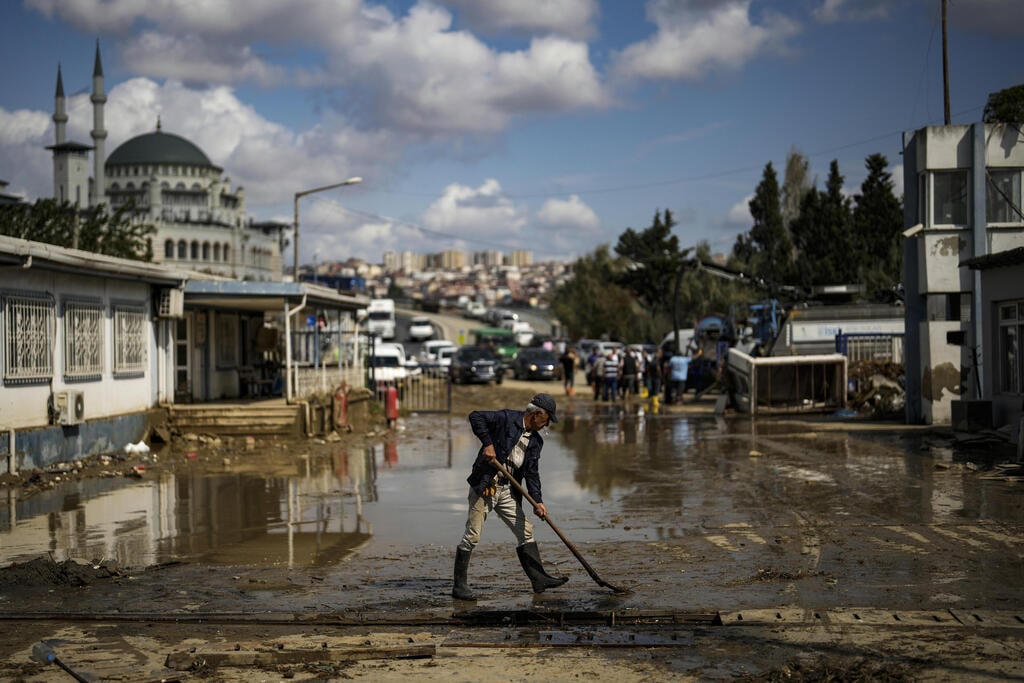 מנקים את הבוץ בבוקר שאחרי (צילום: AP Photo/Khalil Hamra) שיטפונות ב איסטנבול טורקיה