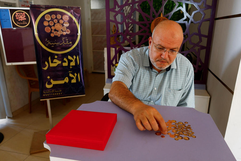 Ahmed Hamdan offers gold coins to low-income residents of the Gaza Strip 