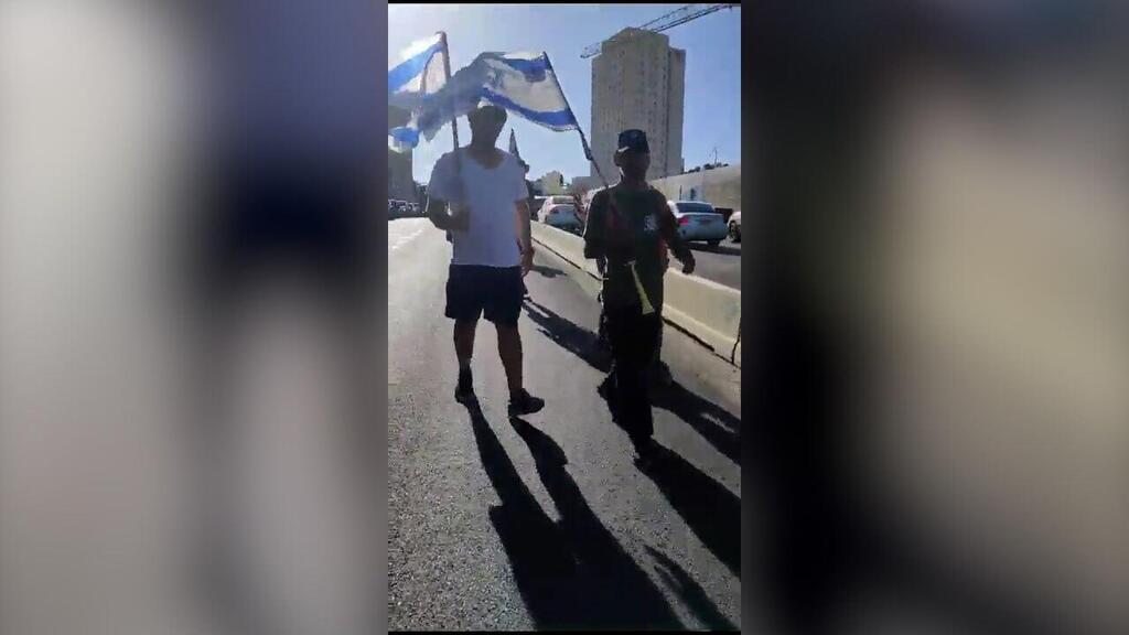 תיעוד: דן אהרונסון מפגין נגד המהפכה המשפטית מנפץ שמשה של רכב בו נמצאים נהגת וילדיה