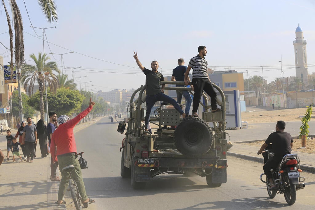 פלסטינים חוגגים על רכב צבאי (צילום: AP Photo/Abed Abu Reash) עזה פלסטינים חוגגים על רכב צבאי