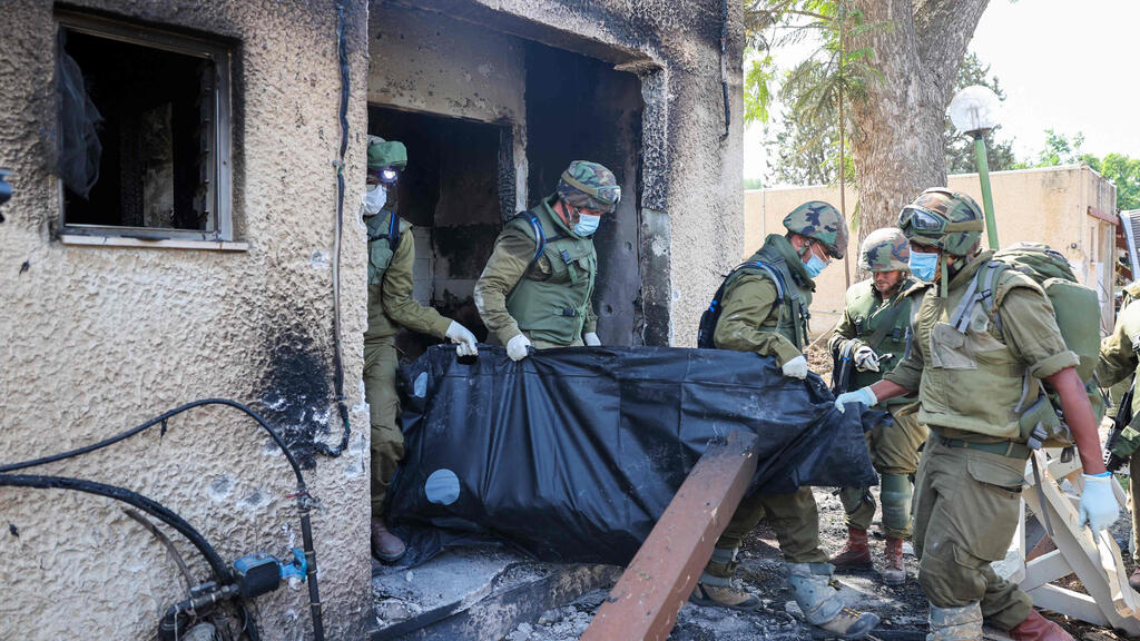 Removing the dead from a burned home in Kfar Aza (Photo: Jack Guez / AFP) כפר עזה