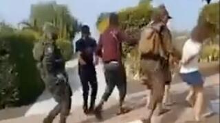 Hamas militants move Israeli hostages down a street in Be’eri, a kibbutz in southern Israel, video posted to X shows 