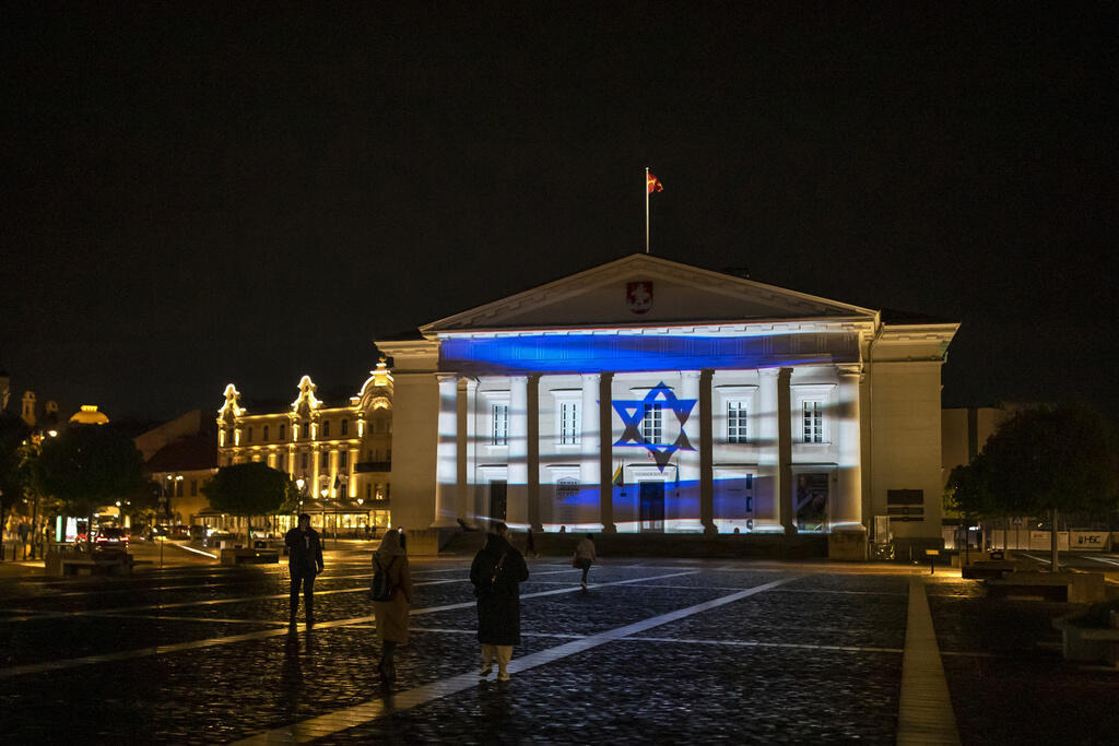 דגל ישראל מוקרן על בניין העירייה בווילנה, בירת ליטא. גם גשר הואר בצבעי הדגל (Mindaugas Kulbis, AP) דגל ישראל מוקרן על בניין העירייה בווילנה, בירת ליטא