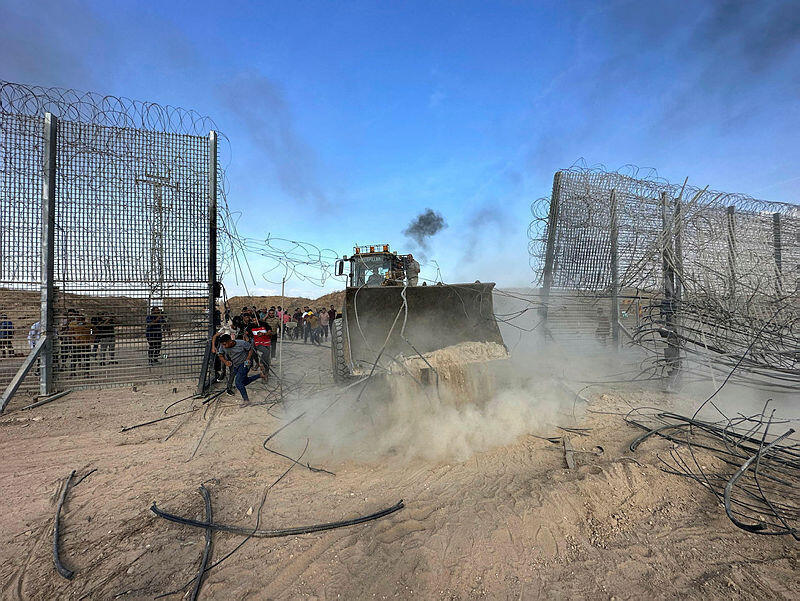 Palestinian front loader breaks through Gaza border fence on October 7, 2023 (Photo: REUTERS/Mohammed Fayq Abu Mostafa) טרקטור פלסטיני פורץ את גדר ההפרדה