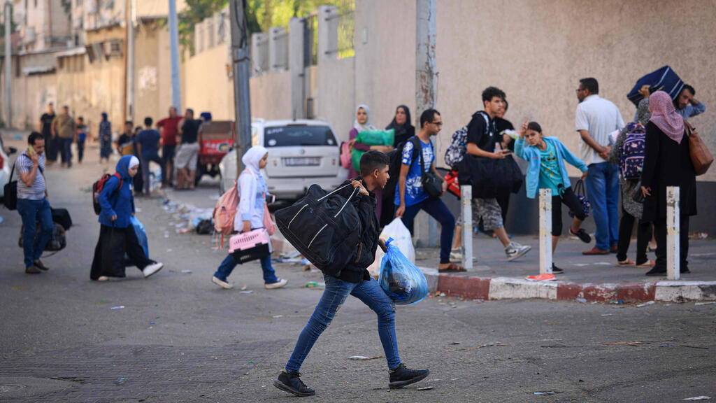 צילום: MAHMUD HAMS / AFP תו/שבי עזה מתפנים מבתיהם