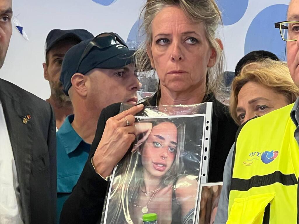 The mother of Maya Shem holding her picture 