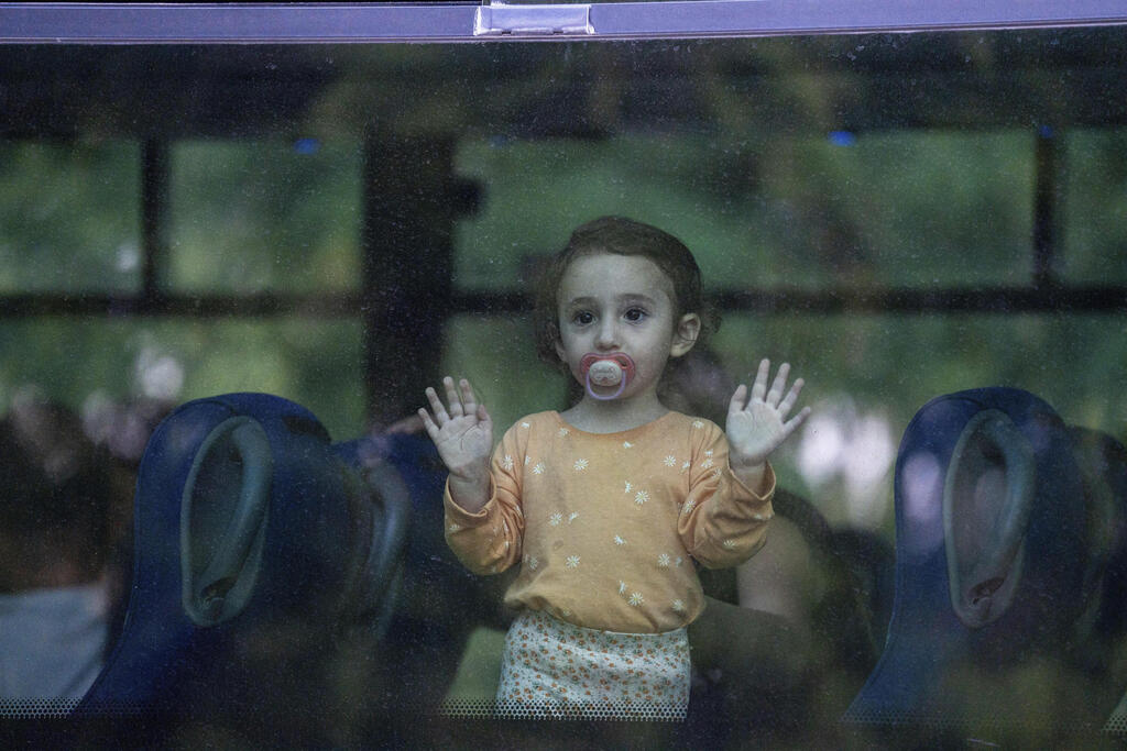 ילדה שפונתה מביתה מביטה מחלון האוטובוס, בקריית שמונה