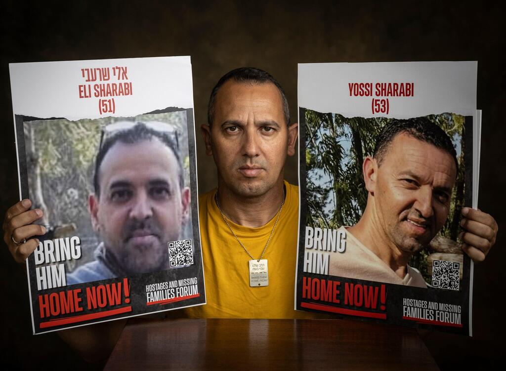 שרון שרעבי עם תמונות אחיו החטופים אלי ויוסי (צילום: אביגיל עוזי ) פרוייקט חטופים: משפחת שרעבי האח ששני אחיו חטופים