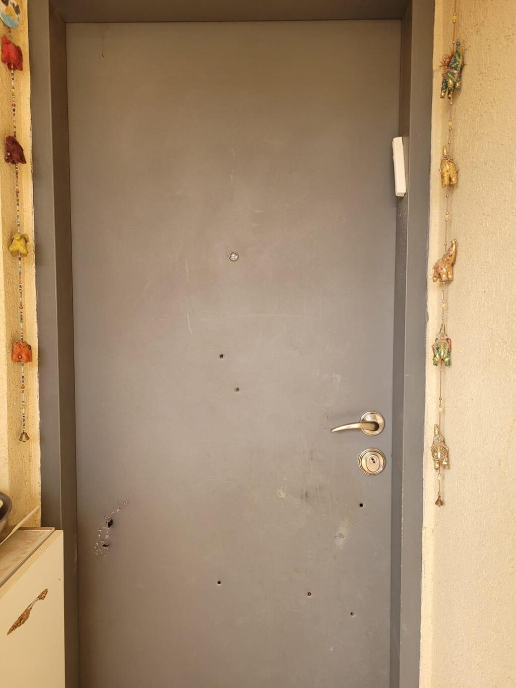 The door of the bomb shelter with bullet holes in it 