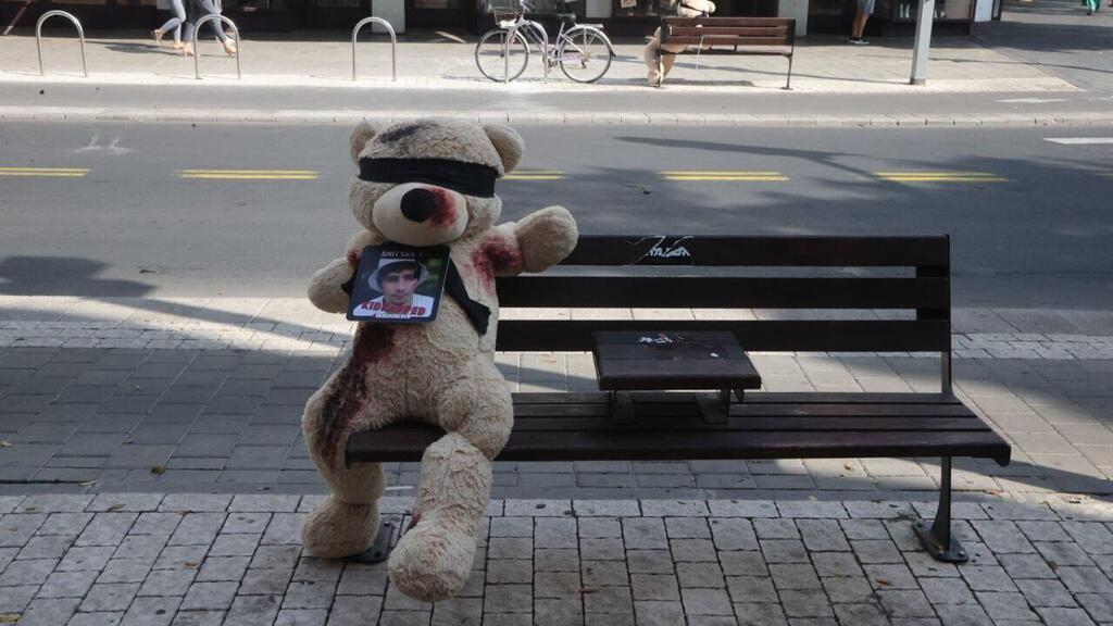 דובים פצועים וקשורים עם תמונות הילדים החטופים לאורך רחוב דיזנגוף, תל אביב